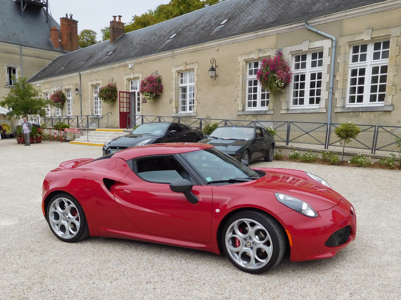 Side profile of red sports coupe with unique alloy wheels.