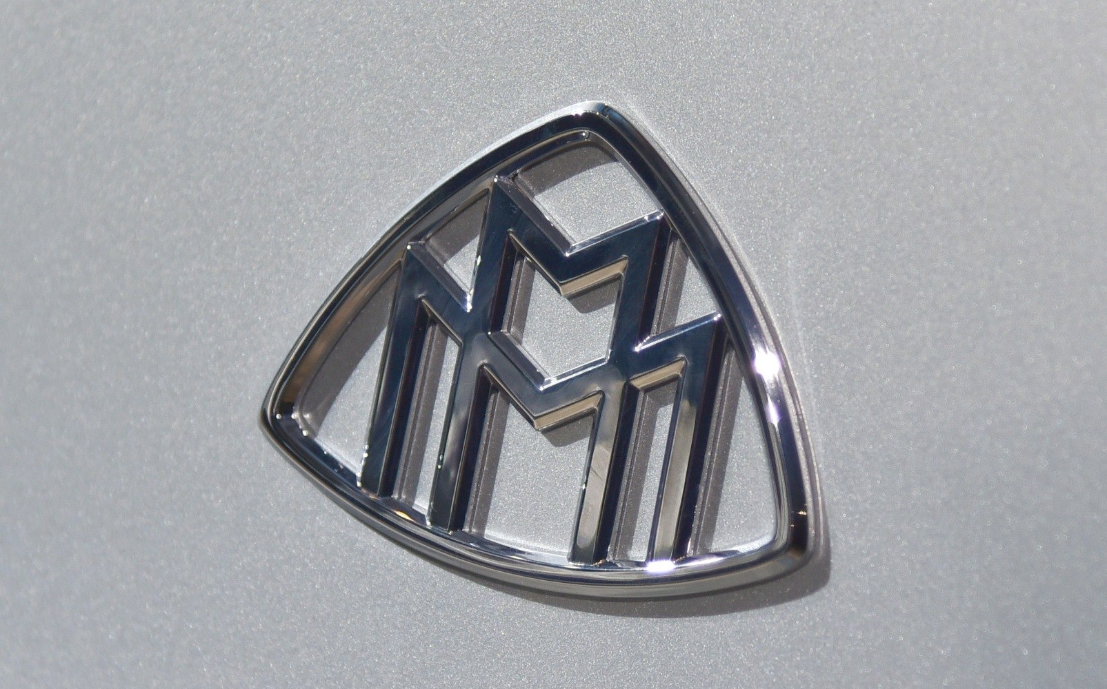 Chrome Maybach emblem with stylized double 'M' design.