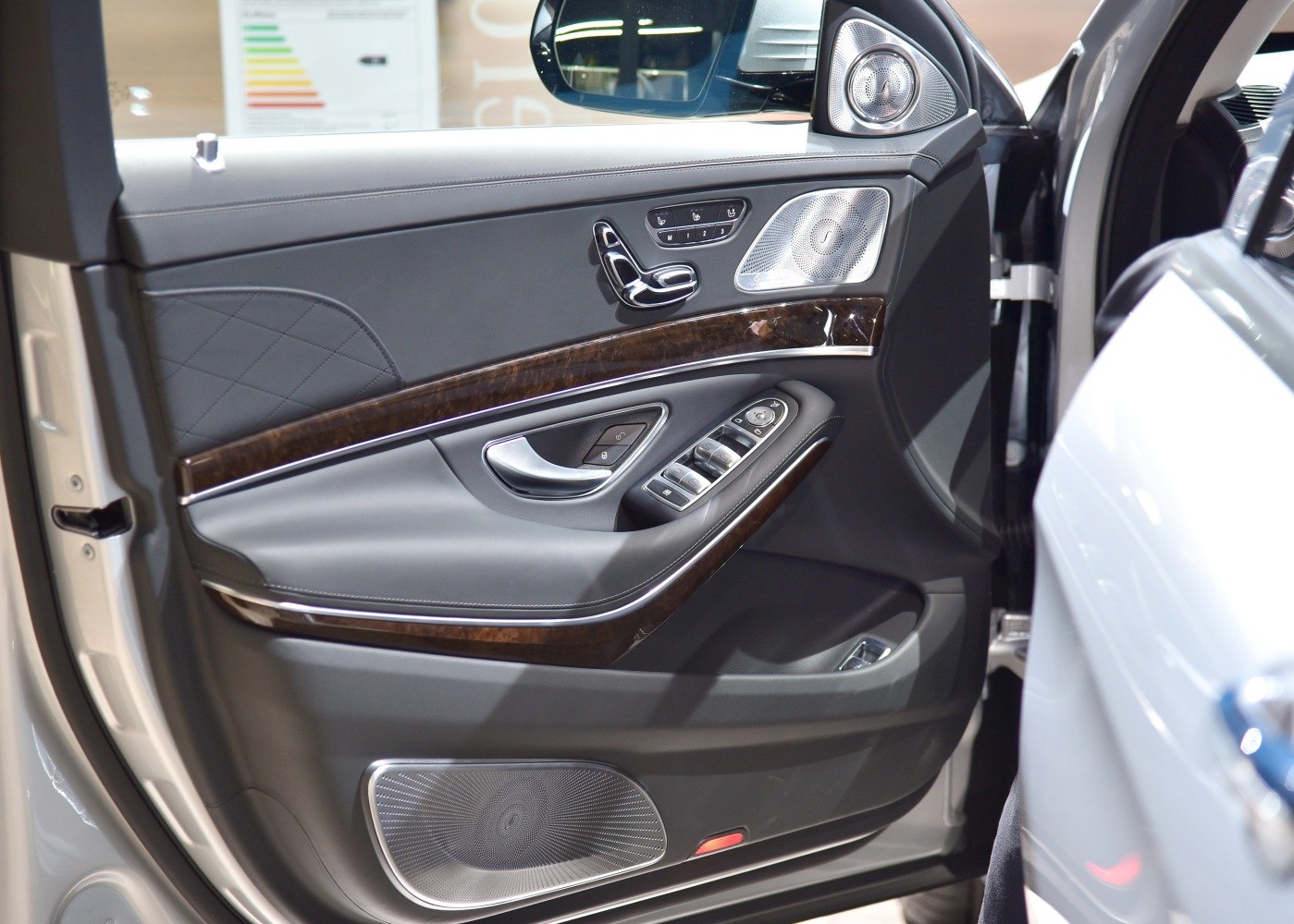 Luxury car door interior with wood trim and premium speaker system