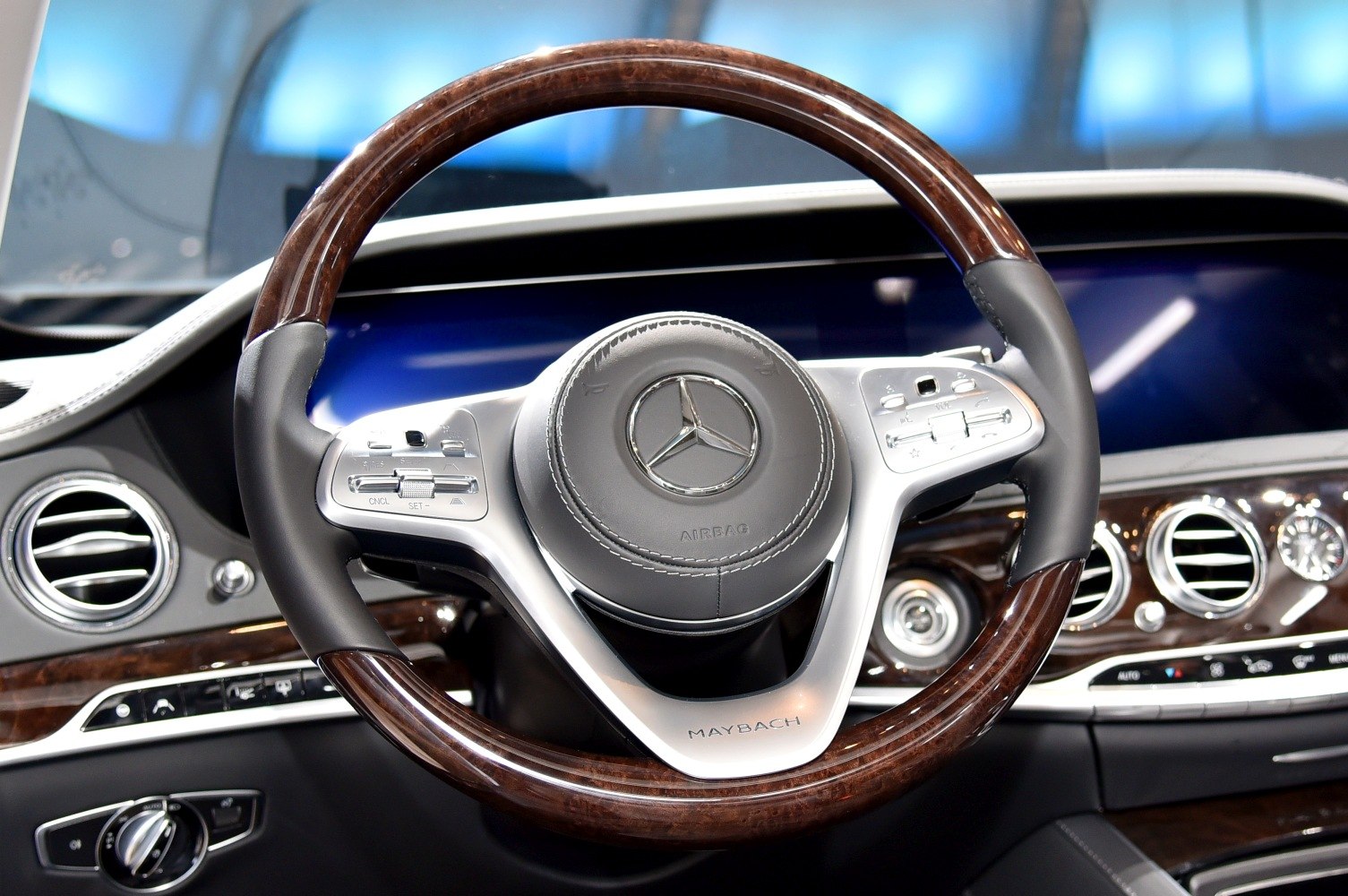 Luxury wood-trimmed steering wheel with integrated controls and digital dashboard