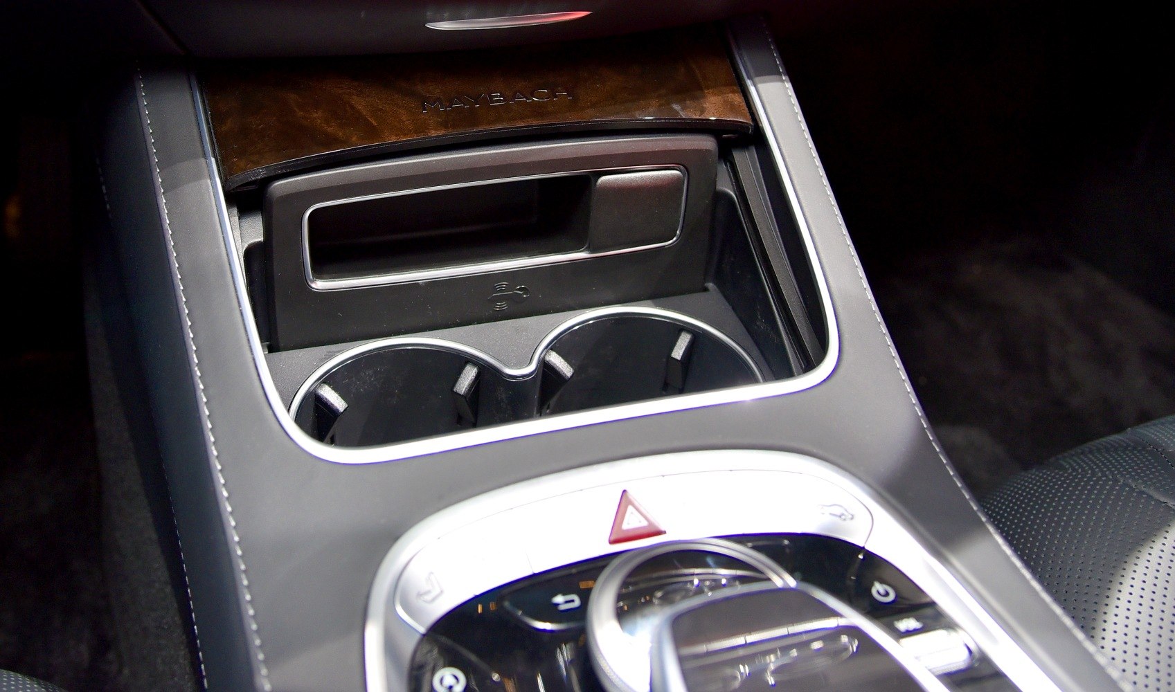 Center console with cup holders and wireless charging pad in luxury car interior