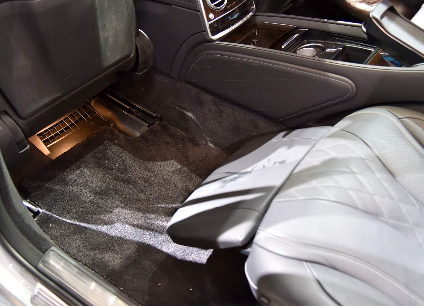 Quilted leather rear seat and plush carpet flooring with ambient lighting.