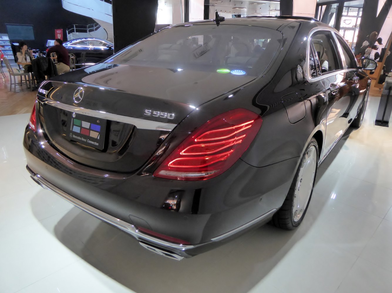 Sleek black sedan rear with LED taillights and dual exhaust.