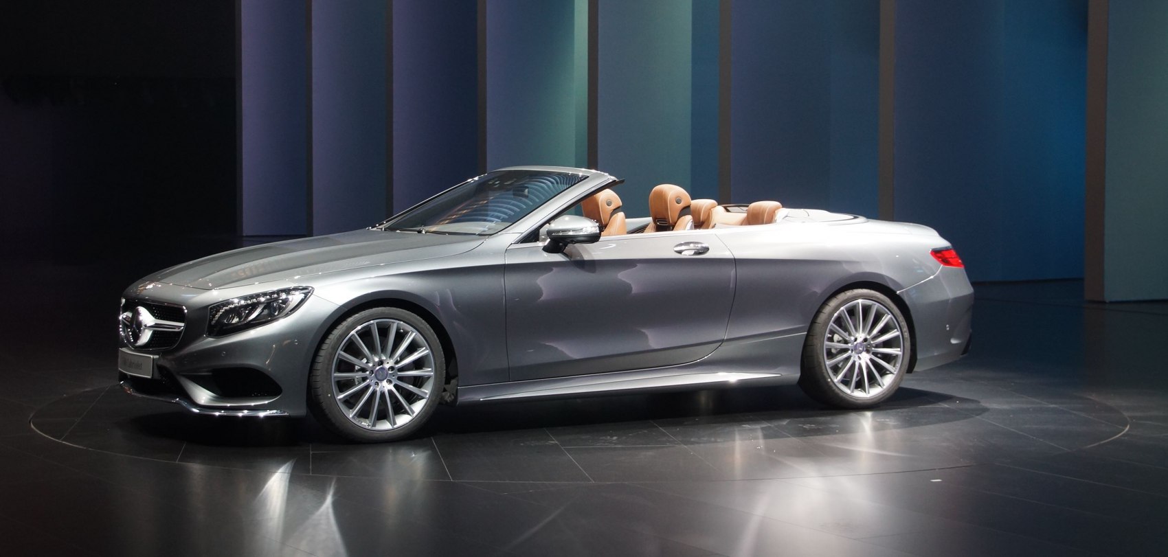 Luxury silver convertible with tan leather interior and multi-spoke wheels