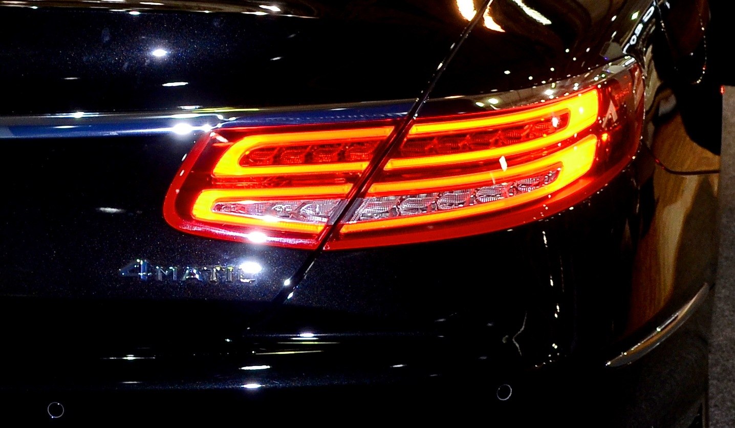 Close-up of a luxury coupe’s distinctive LED taillight and 4MATIC badge.