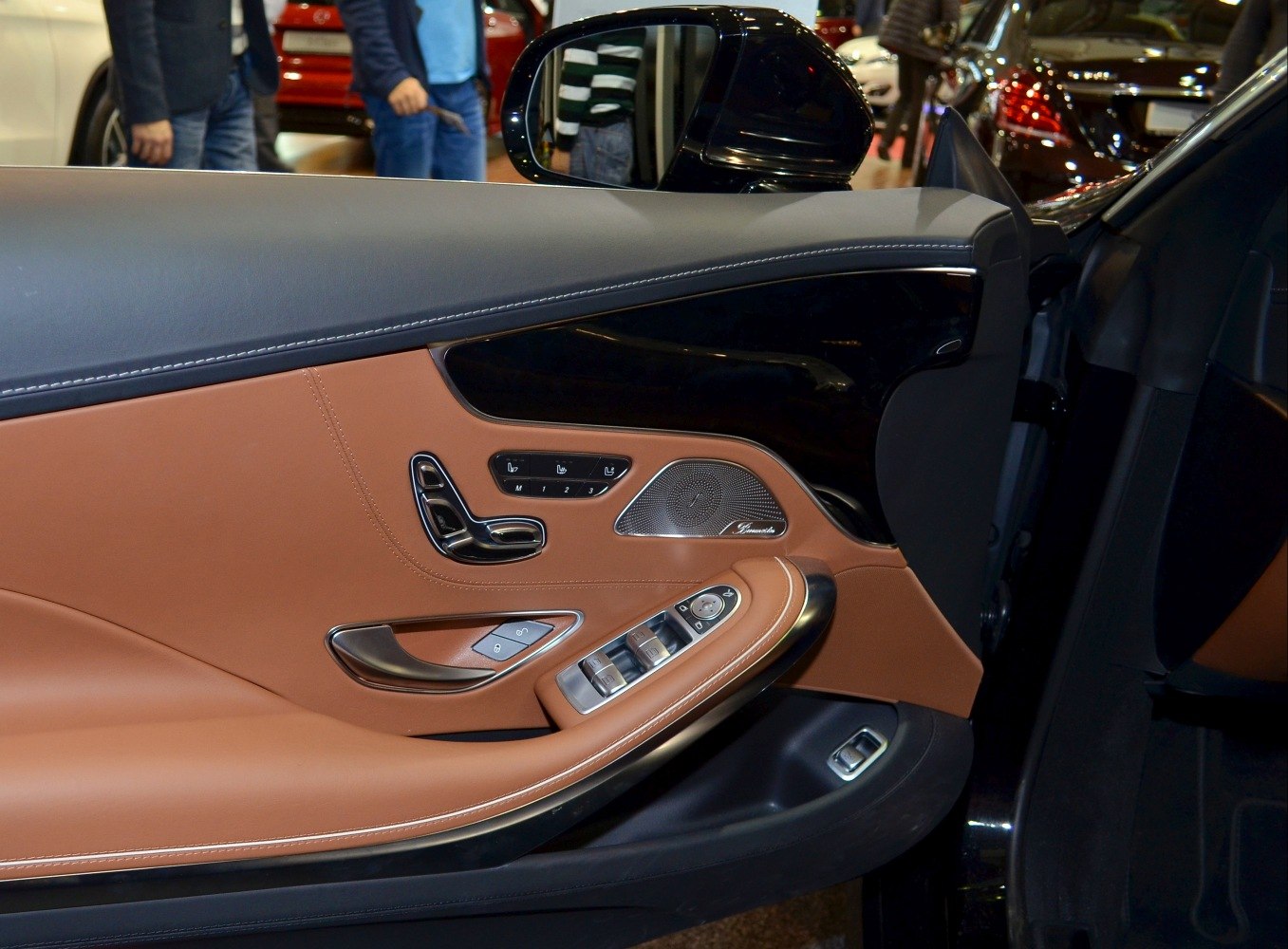 Luxury interior door panel with seat and window controls, premium materials.