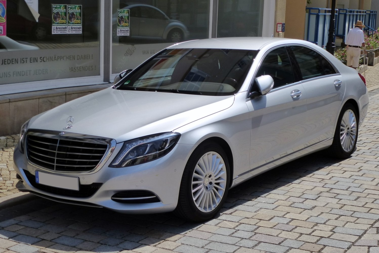 Front grille and side profile of a luxury sedan on pavement