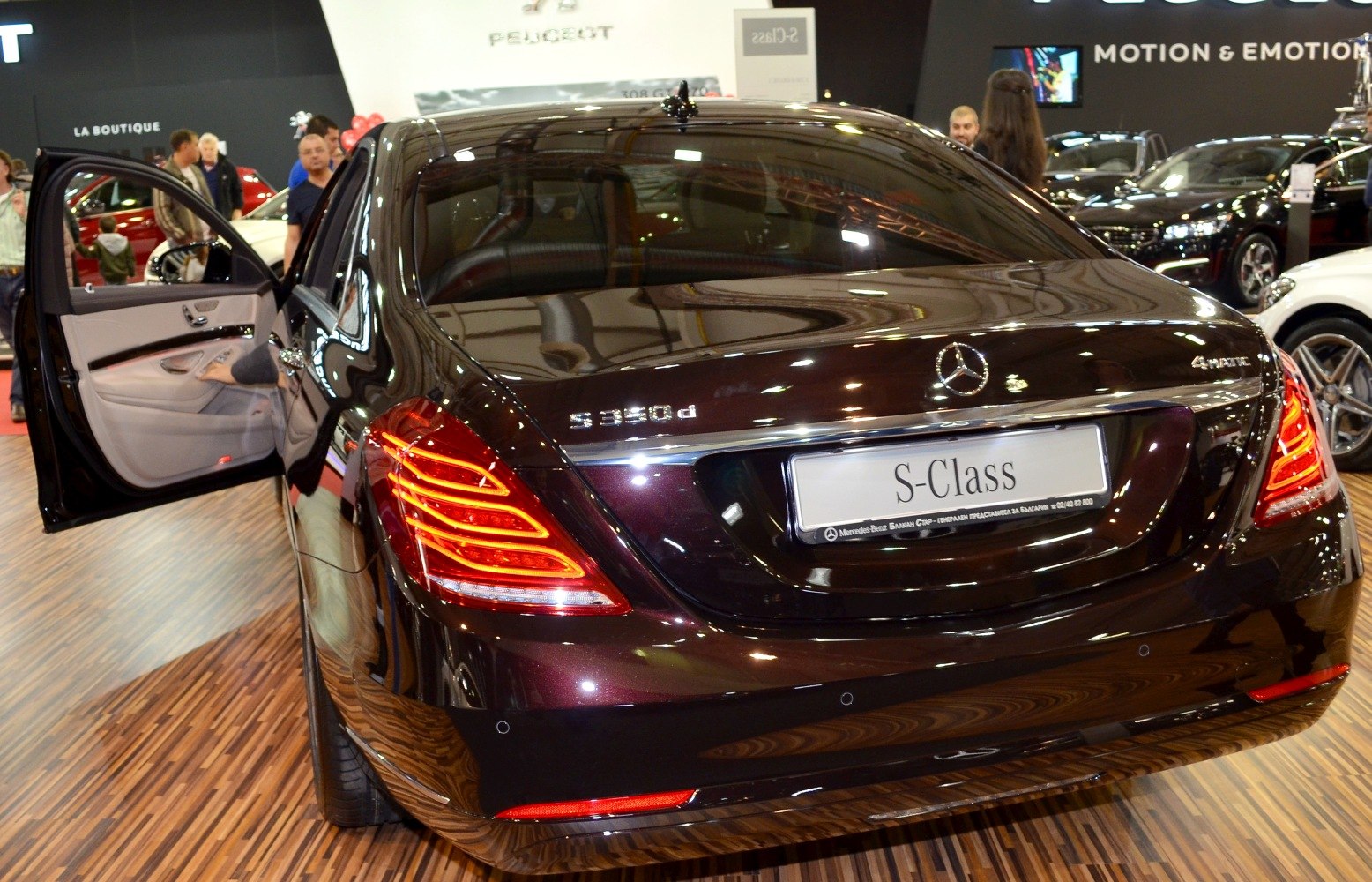 Luxury sedan rear with LED taillights and open door