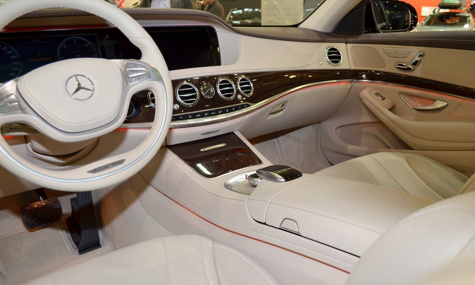 Beige leather luxury interior with wood trim and advanced control panel.