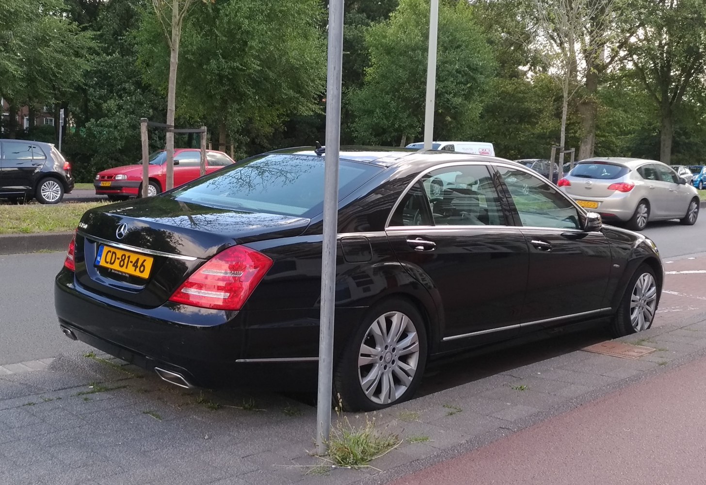 Rear-side view of black luxury sedan with distinctive tail lights and chrome trims