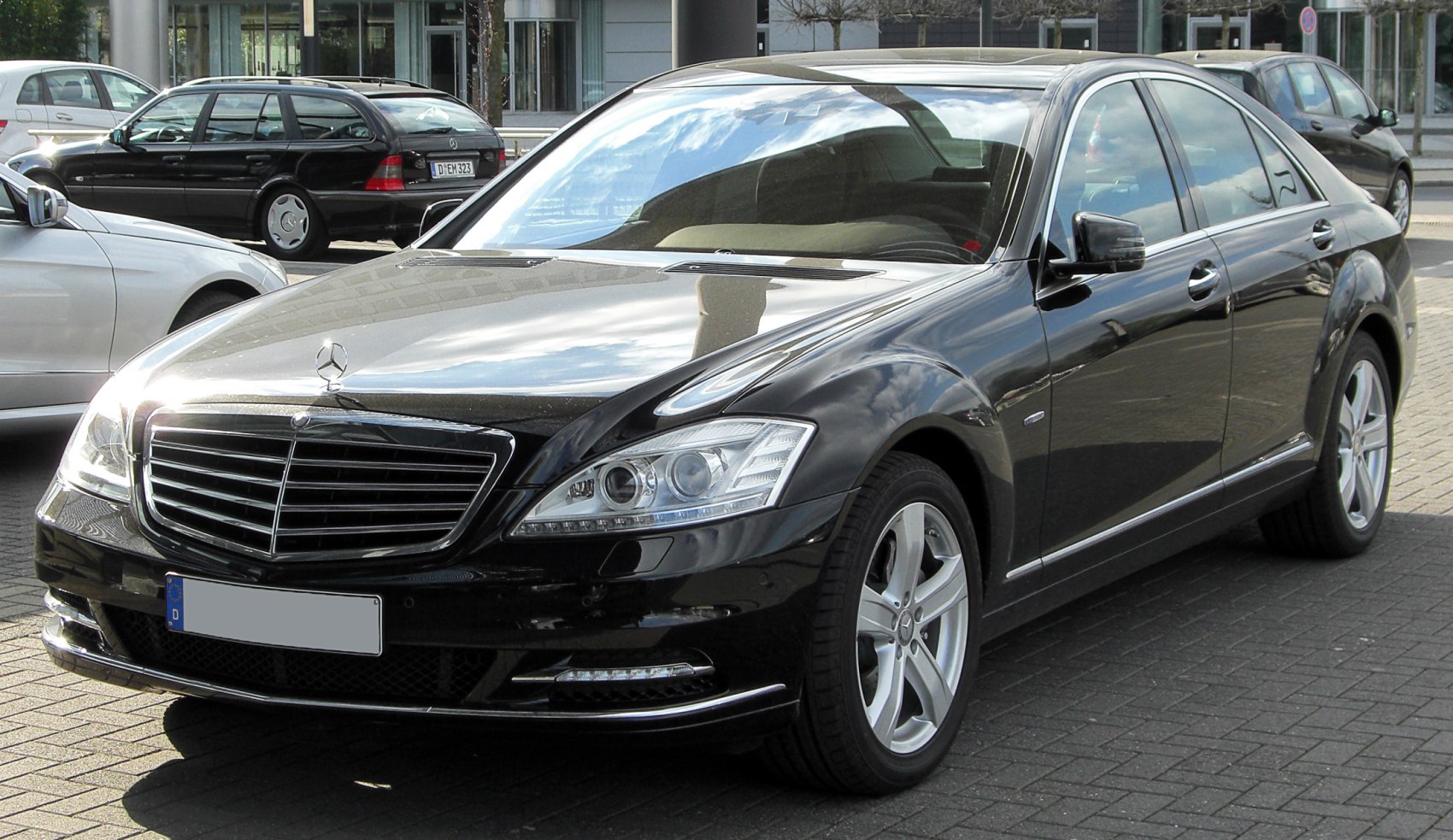 Front and side view of a black luxury sedan with modern headlights and alloy wheels