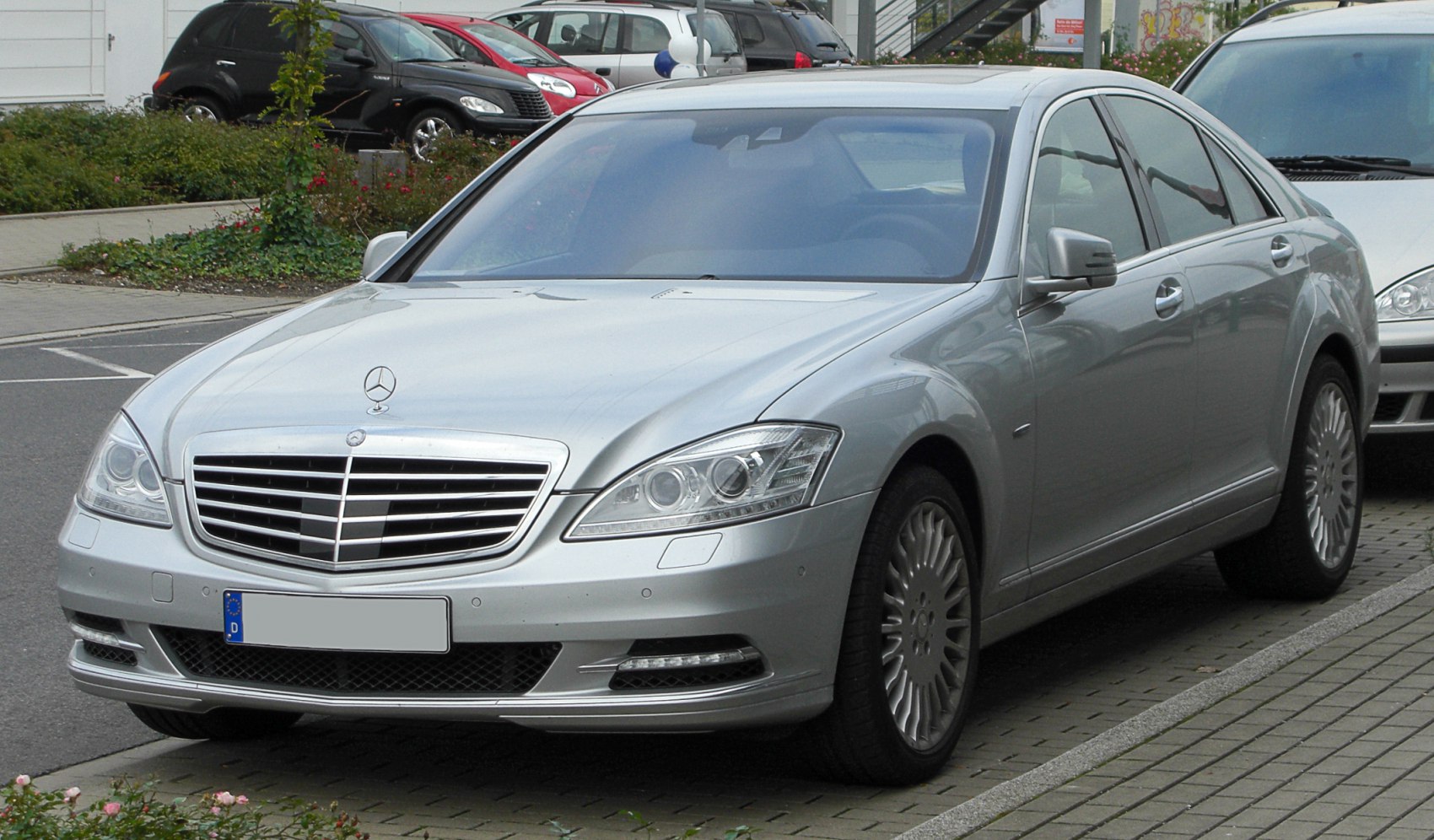 Silver luxury sedan with chrome grille and dual projector headlights