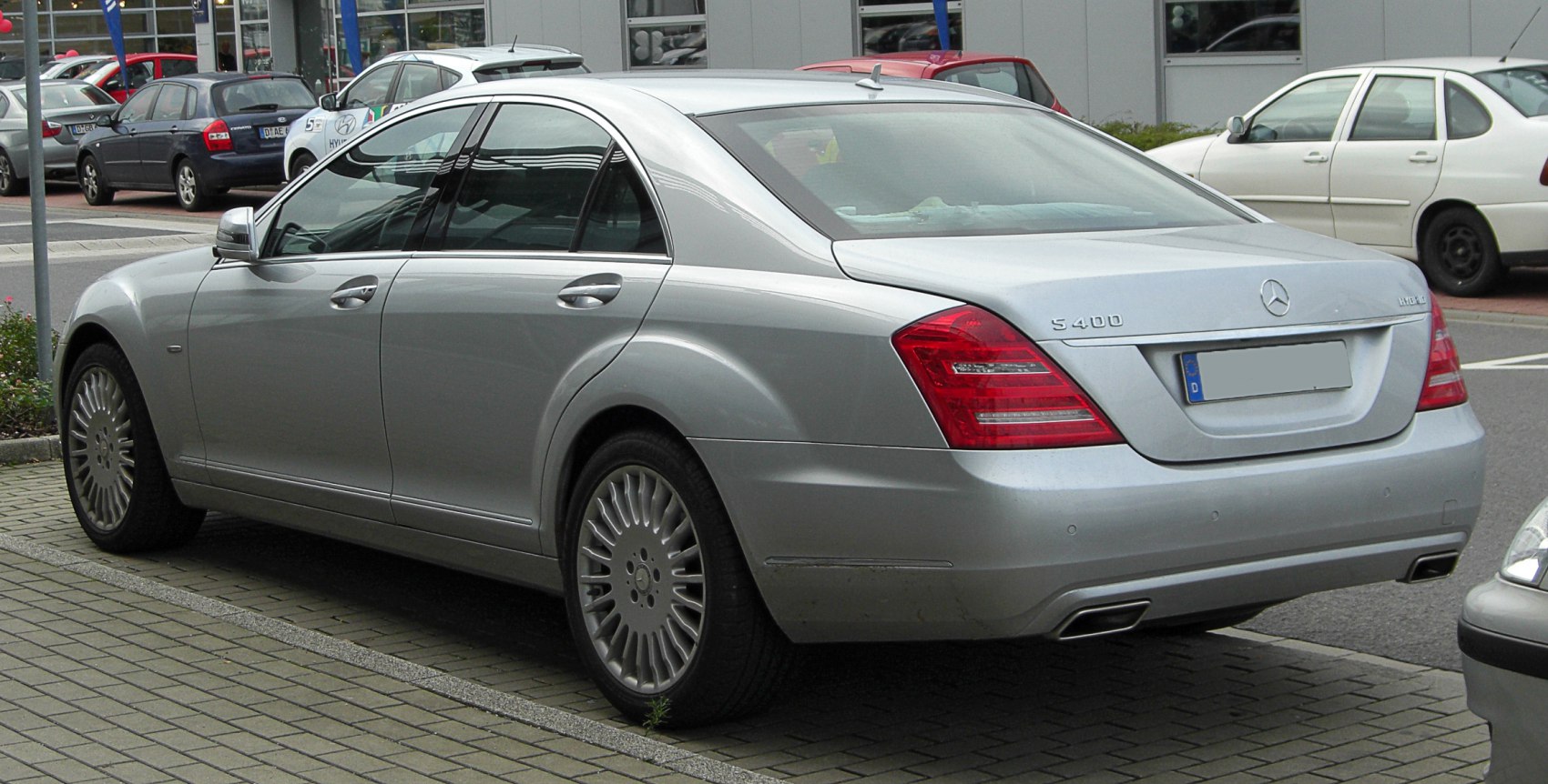 Silver luxury sedan rear with distinct taillights and alloy wheels