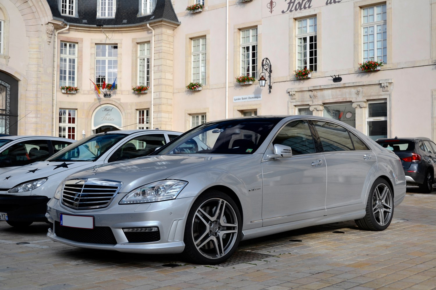 Luxury sedan front side view with AMG sport wheels and chrome grille