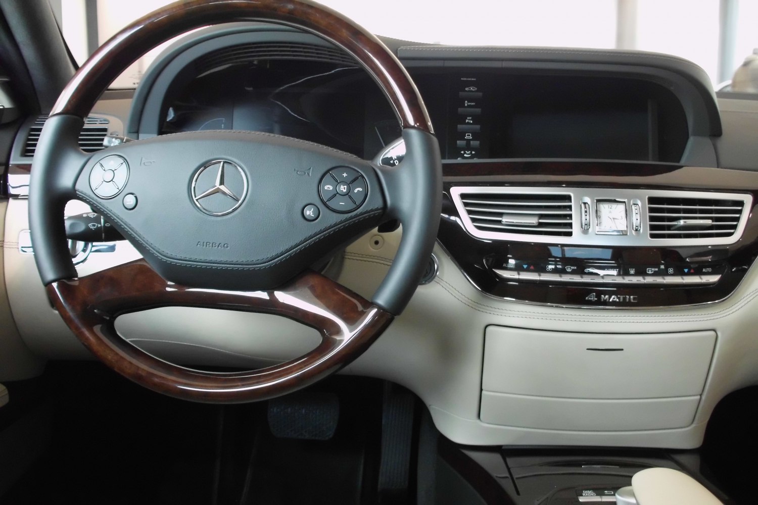Wood-trimmed steering wheel and dashboard with analog clock and controls