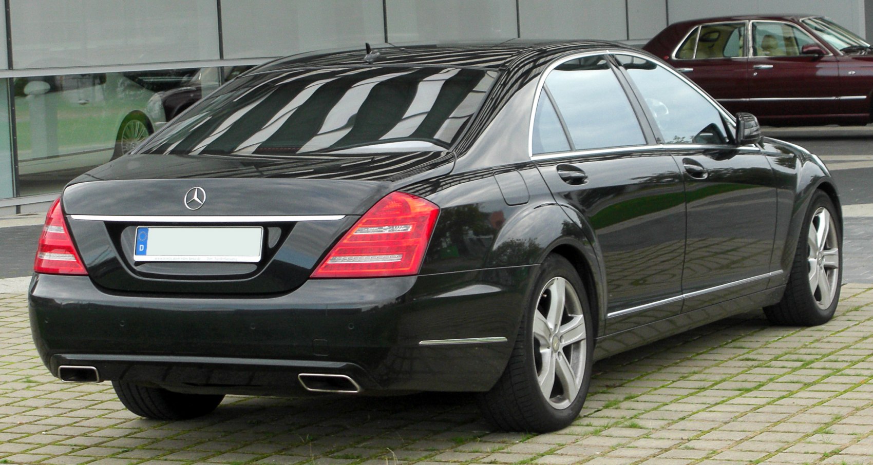 Rear view of luxury sedan with polished taillights and dual exhaust tips.