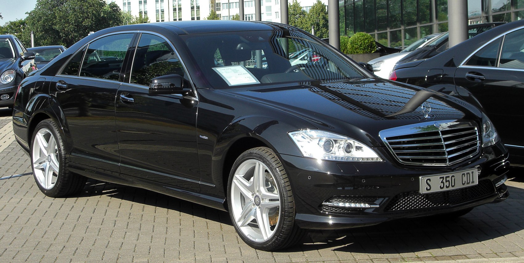 Front side view of luxury sedan with AMG wheels and LED headlights