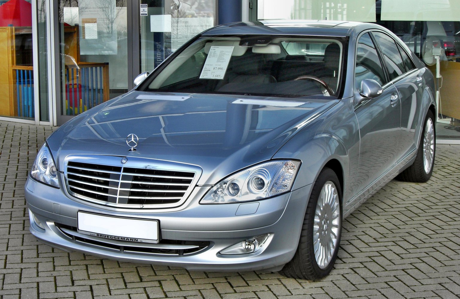 Luxury sedan front with chrome grille, LED headlights, and alloy wheels.