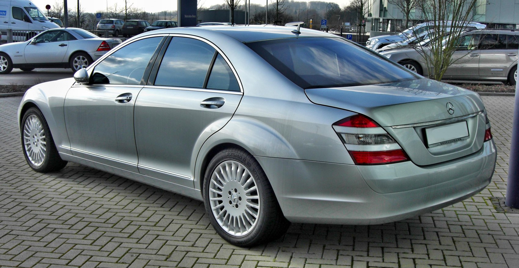 Rear side view of silver sedan with multi-spoke alloy wheels and tinted windows