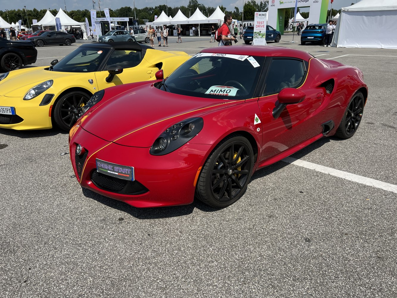 Two sporty cars, one red and one yellow, with aerodynamic shapes and distinct black wheels.