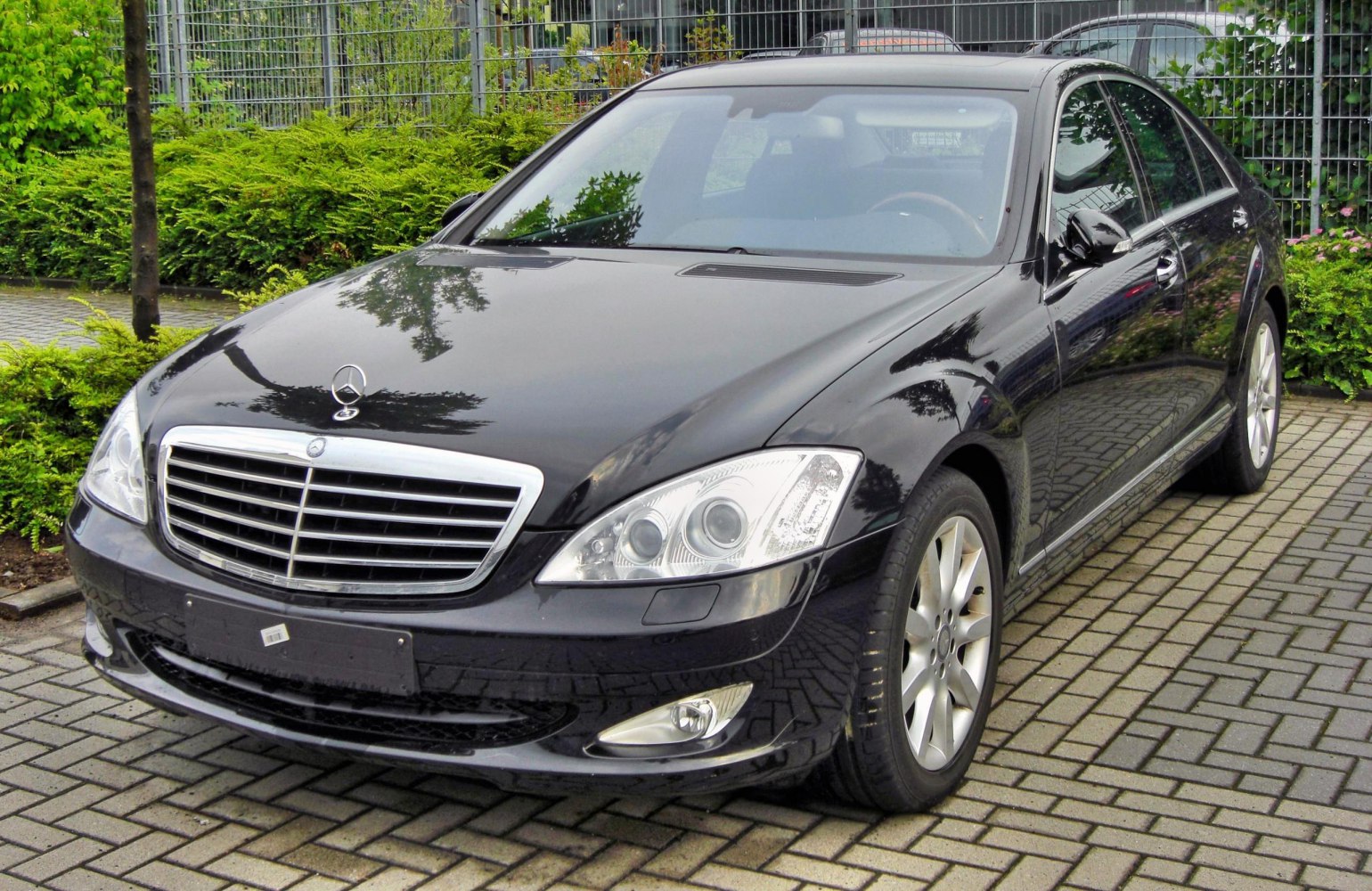 Front side view of luxury sedan with prominent grille and dual round headlights