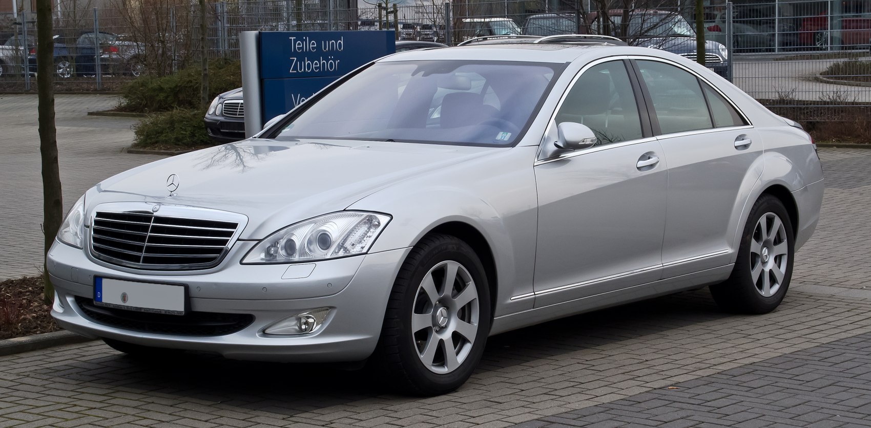 Silver luxury sedan front side with alloy wheels