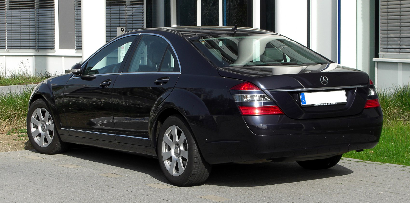 Rear side view of luxury sedan with distinct taillights and alloy wheels