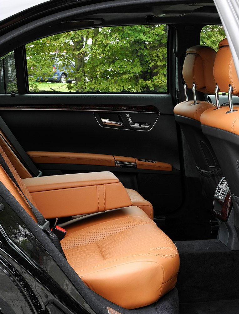 Luxury rear seat with tan leather and foldable armrest in premium sedan