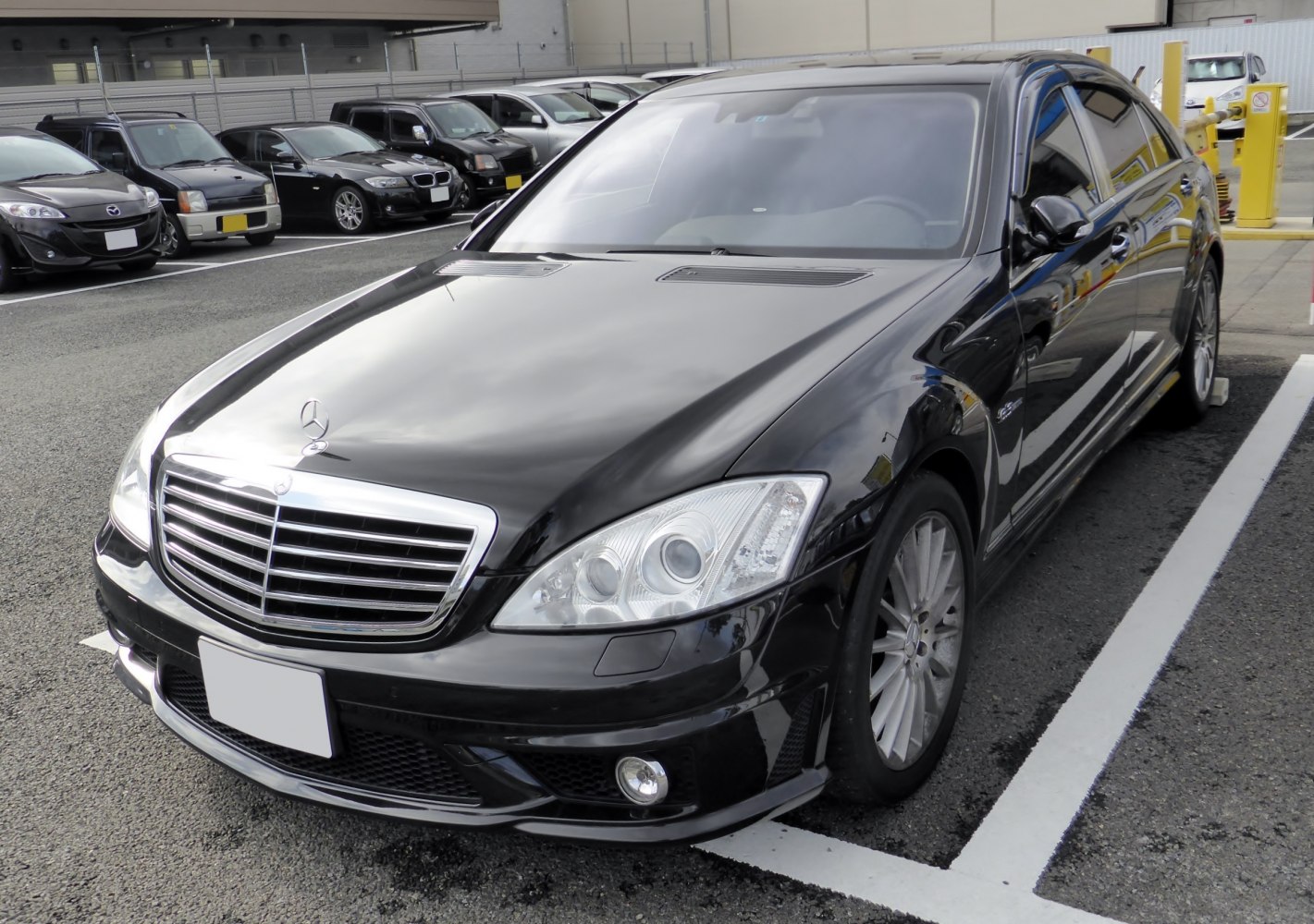 Front and side view of a black luxury sedan with chrome grille and multi-spoke wheels