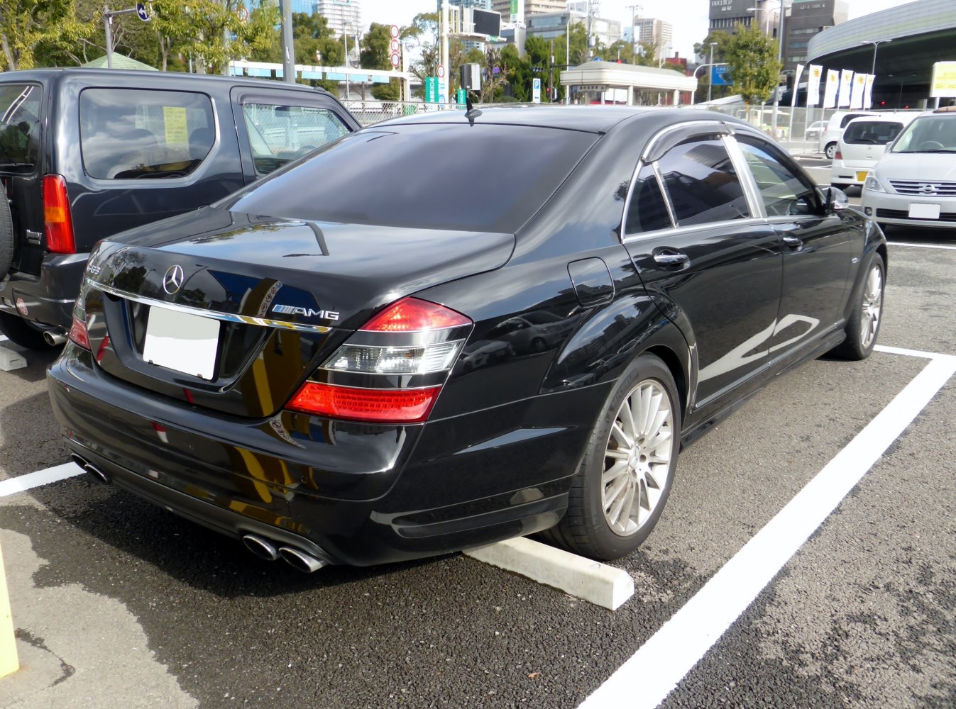 Rear and side view with AMG badge, quad exhaust, tinted windows.