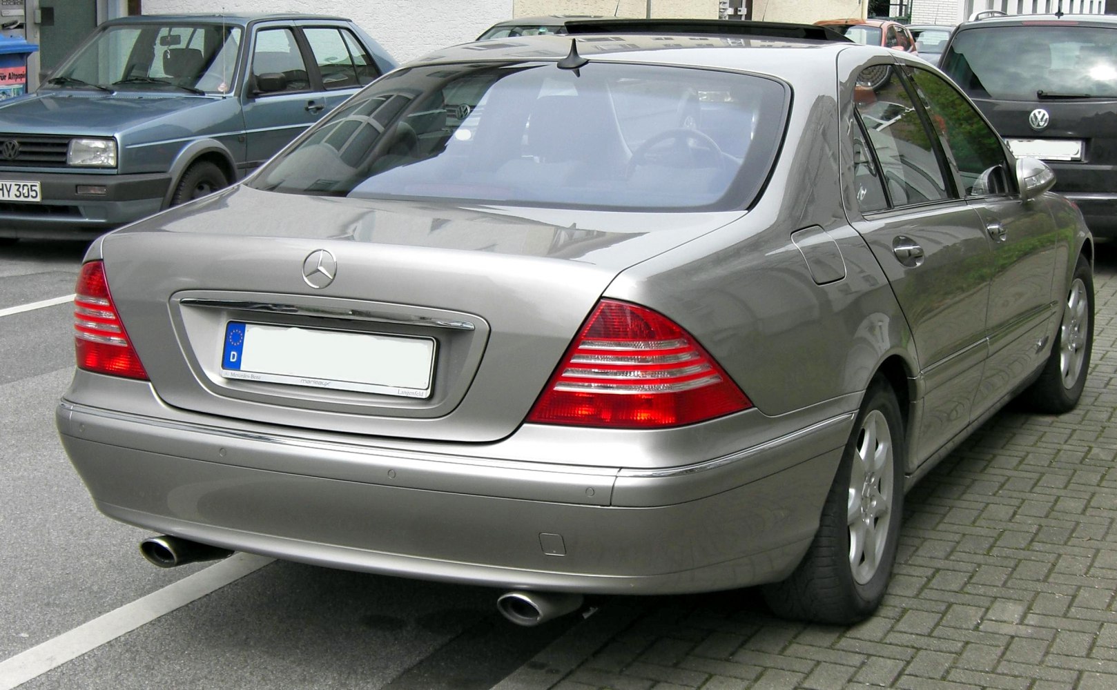 Silver sedan rear view with distinct tail lights and dual exhaust pipes