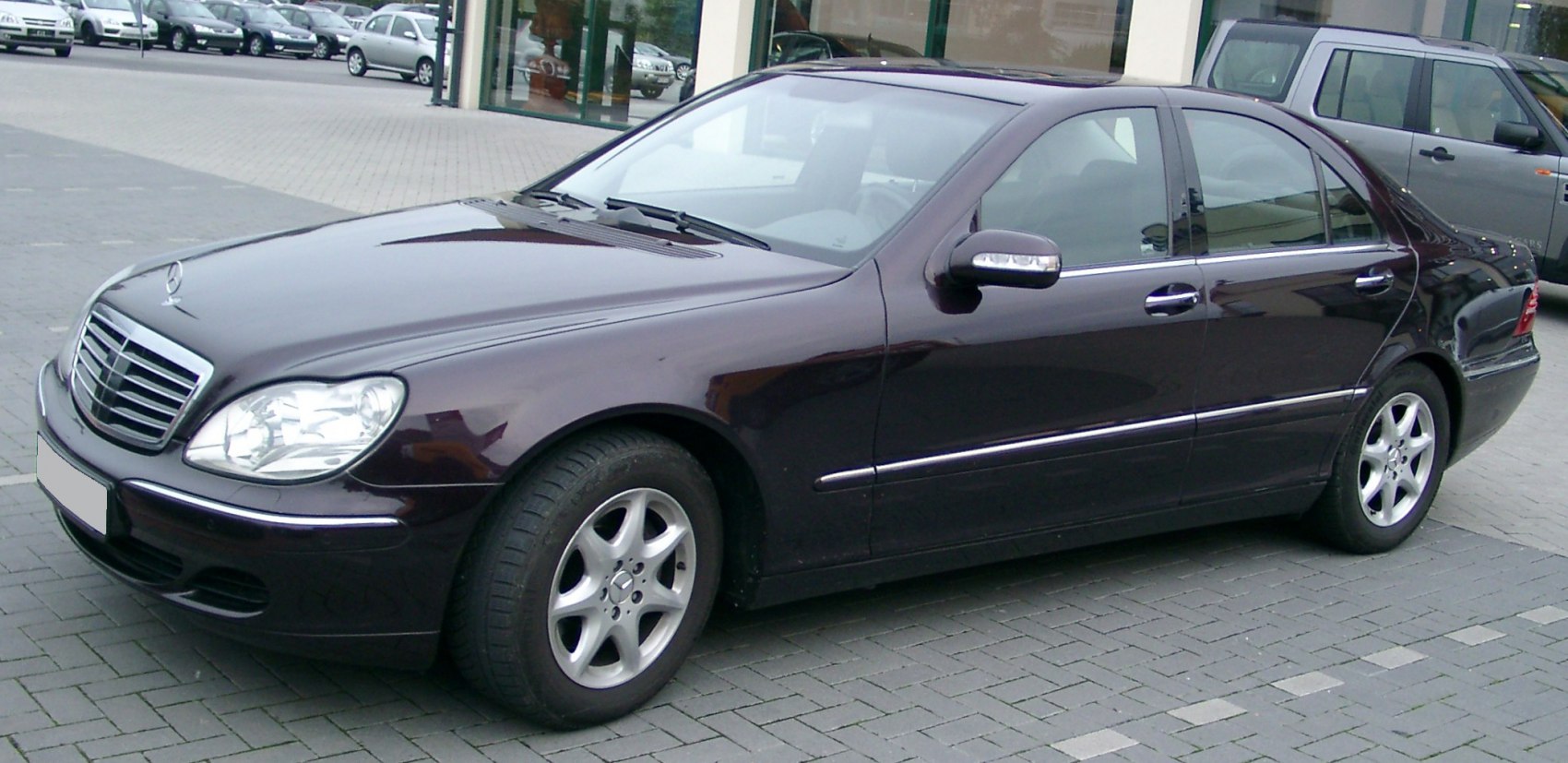 Side and front profile of luxury sedan with chrome grille and alloy wheels