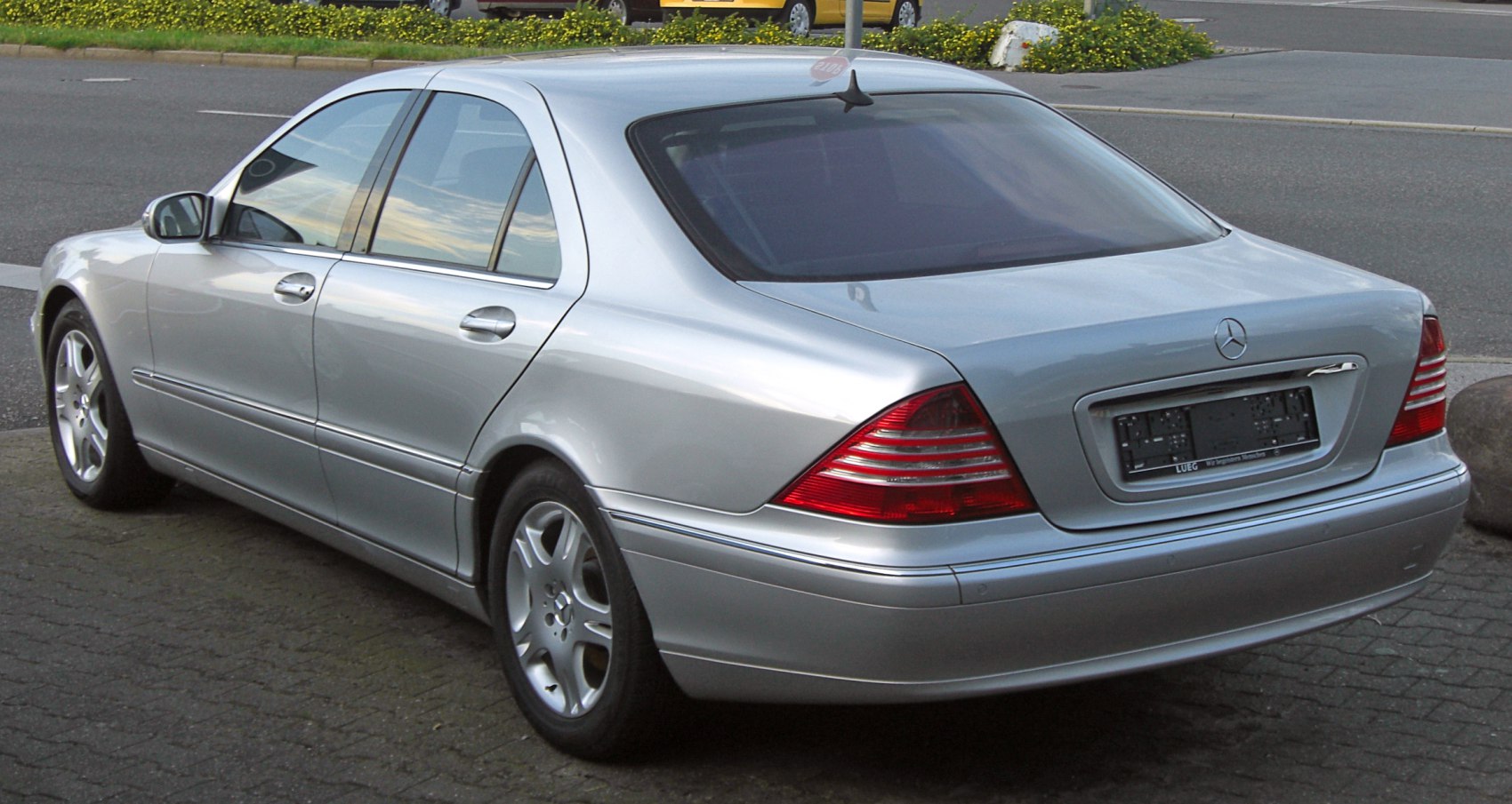 Silver luxury sedan rear with distinctive taillights and smooth body lines.