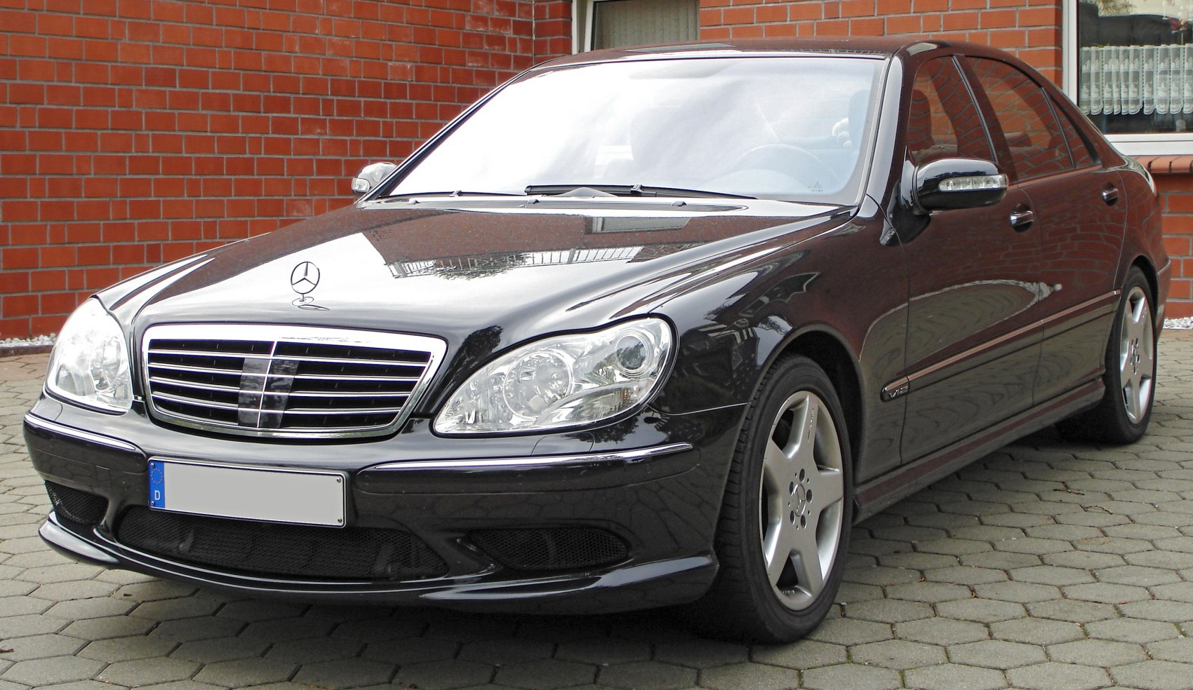 Front grille and side profile of a luxury sedan with alloy wheels and V12 badge