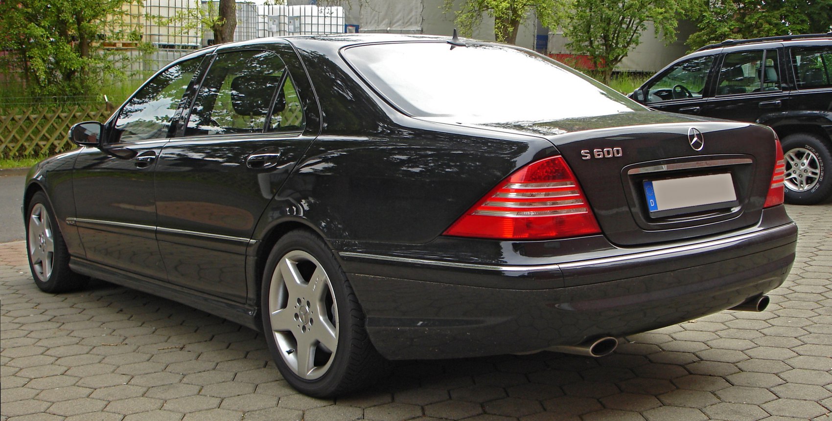 Rear side of long luxury sedan with distinct tail lights and alloy wheels