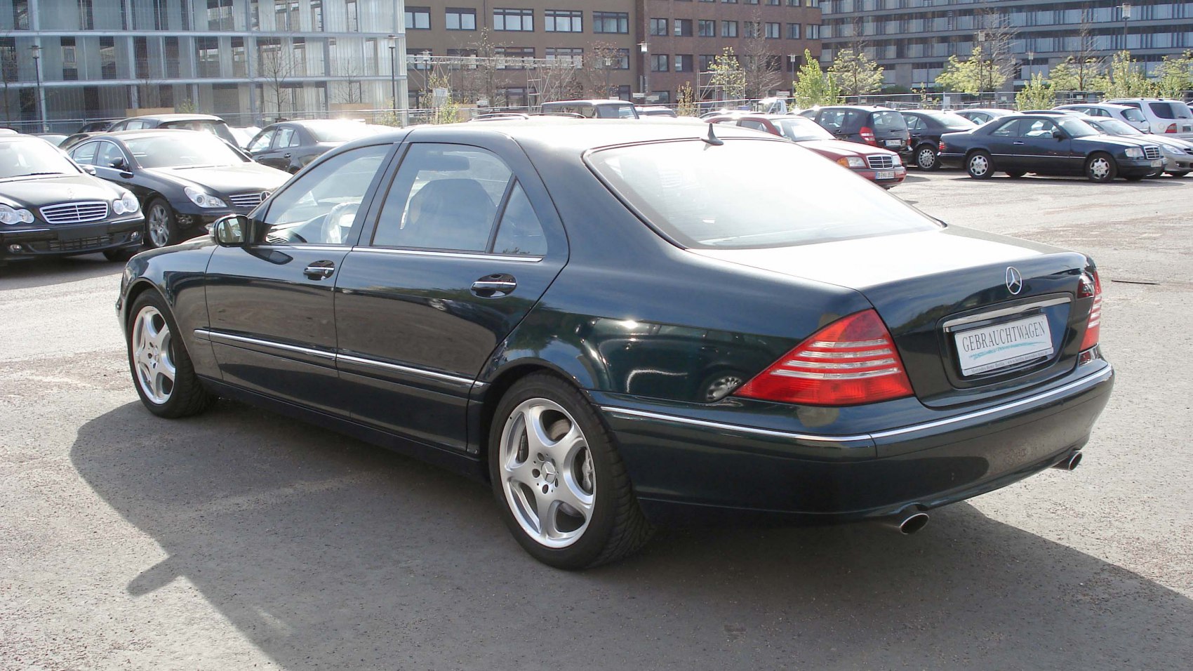 Luxury long sedan rear and side view with distinctive tail lights and alloy wheels