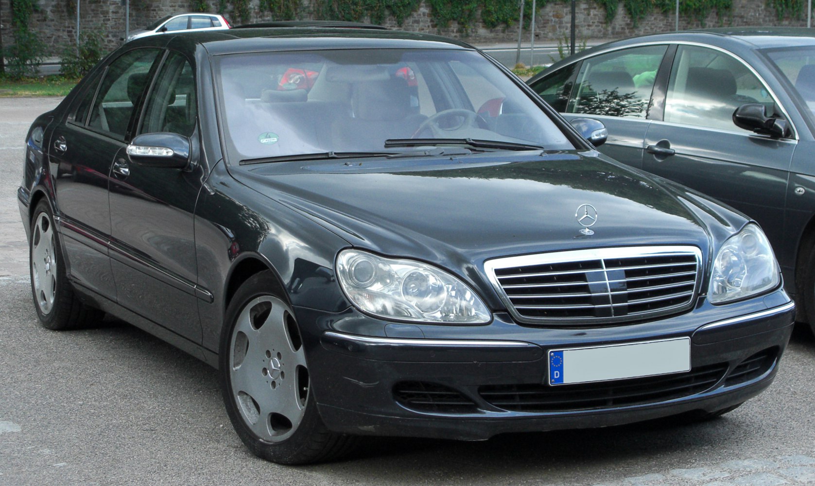 Luxury sedan front view with distinctive AMG wheels and prominent grille