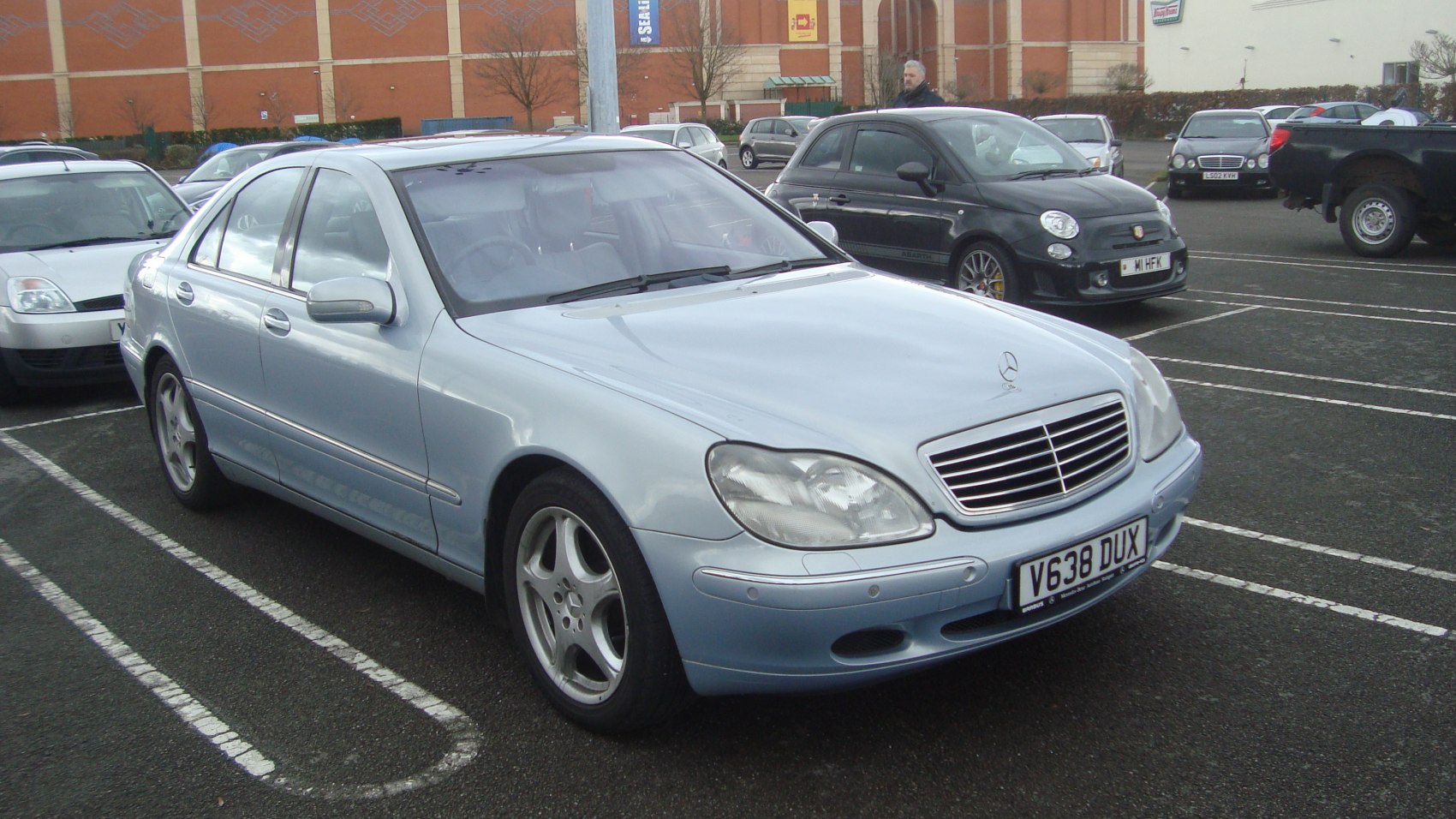 Front and side view of classic luxury sedan with prominent grille and alloy wheels