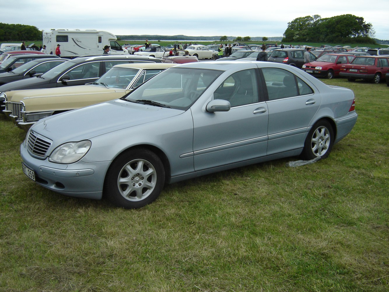 Side profile of a luxury sedan with smooth flowing lines and alloy wheels