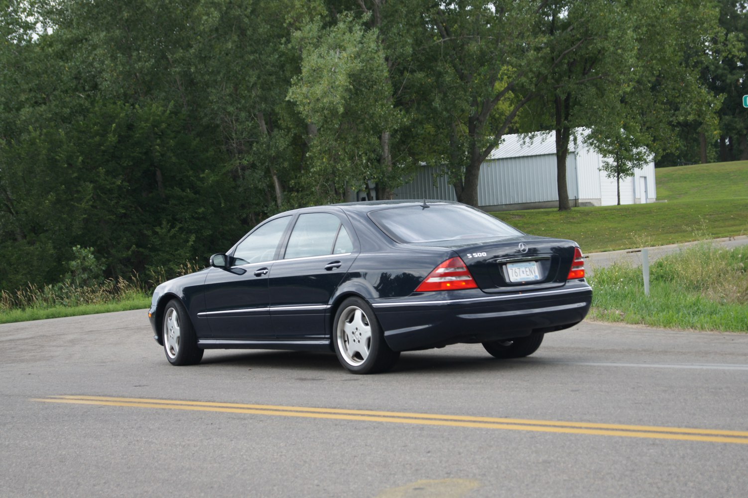 Rear three-quarter view of a luxury sedan with distinctive tail lights and alloy wheels.