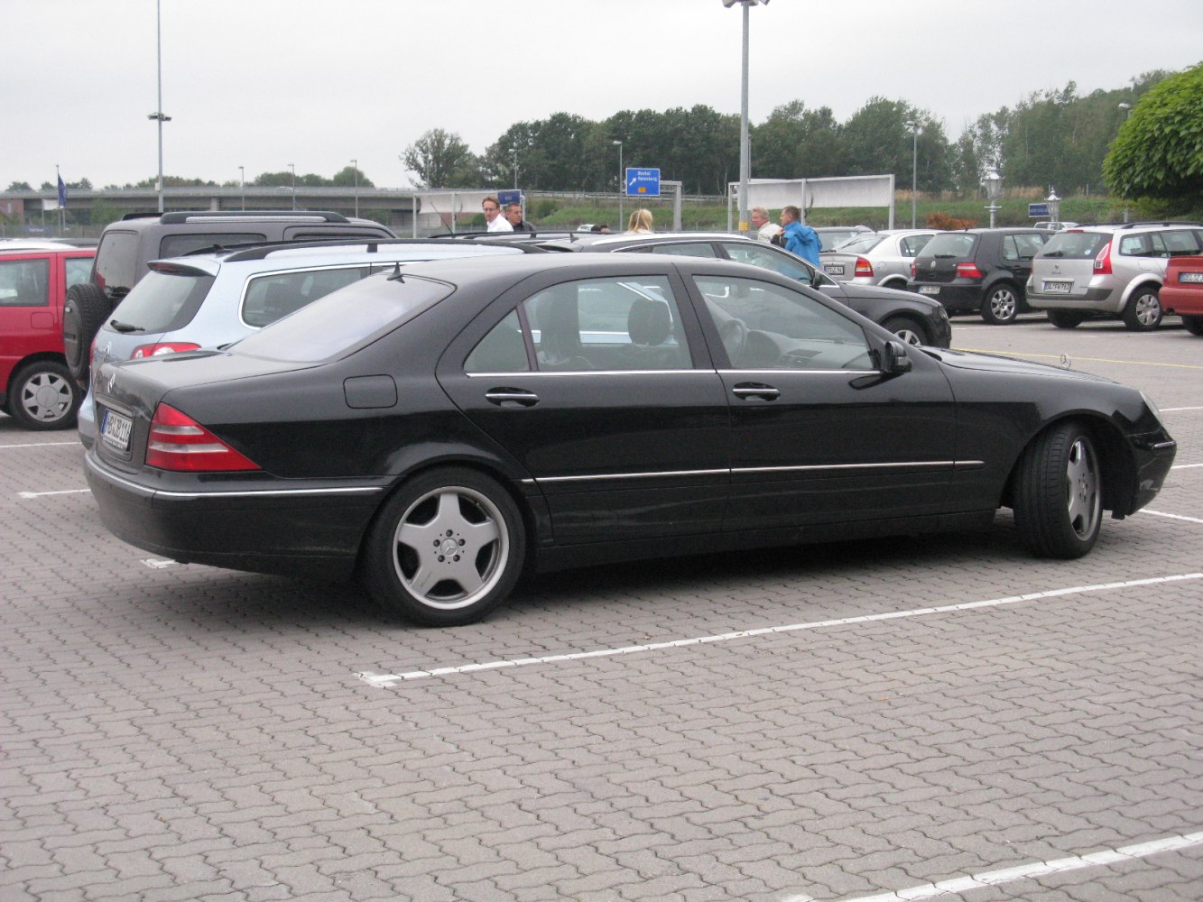 Side view of black luxury sedan with elongated body and five-spoke wheels