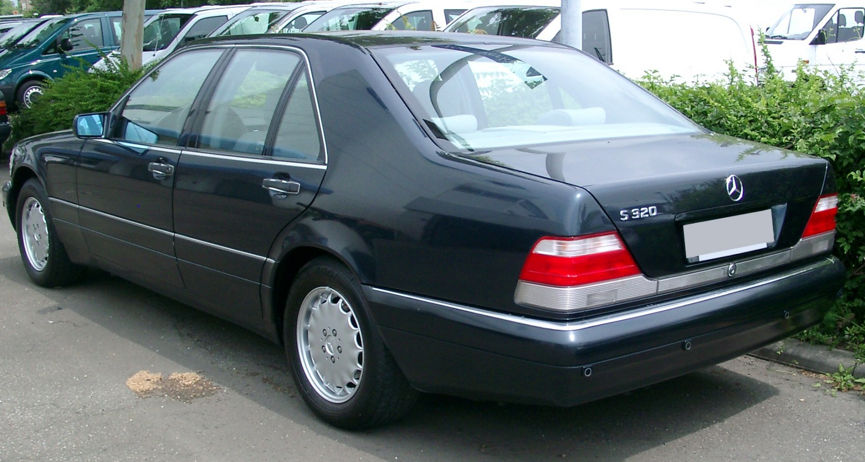Rear side view of a luxury sedan with classic taillights and alloy wheels