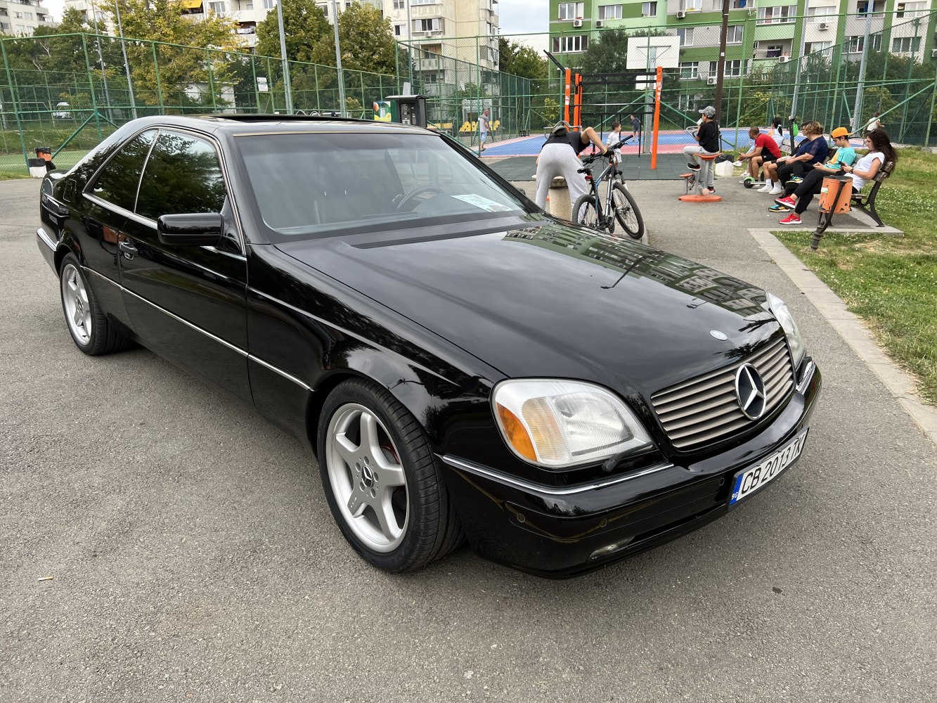 Sleek black sedan with rounded headlights and horizontal chrome grille.