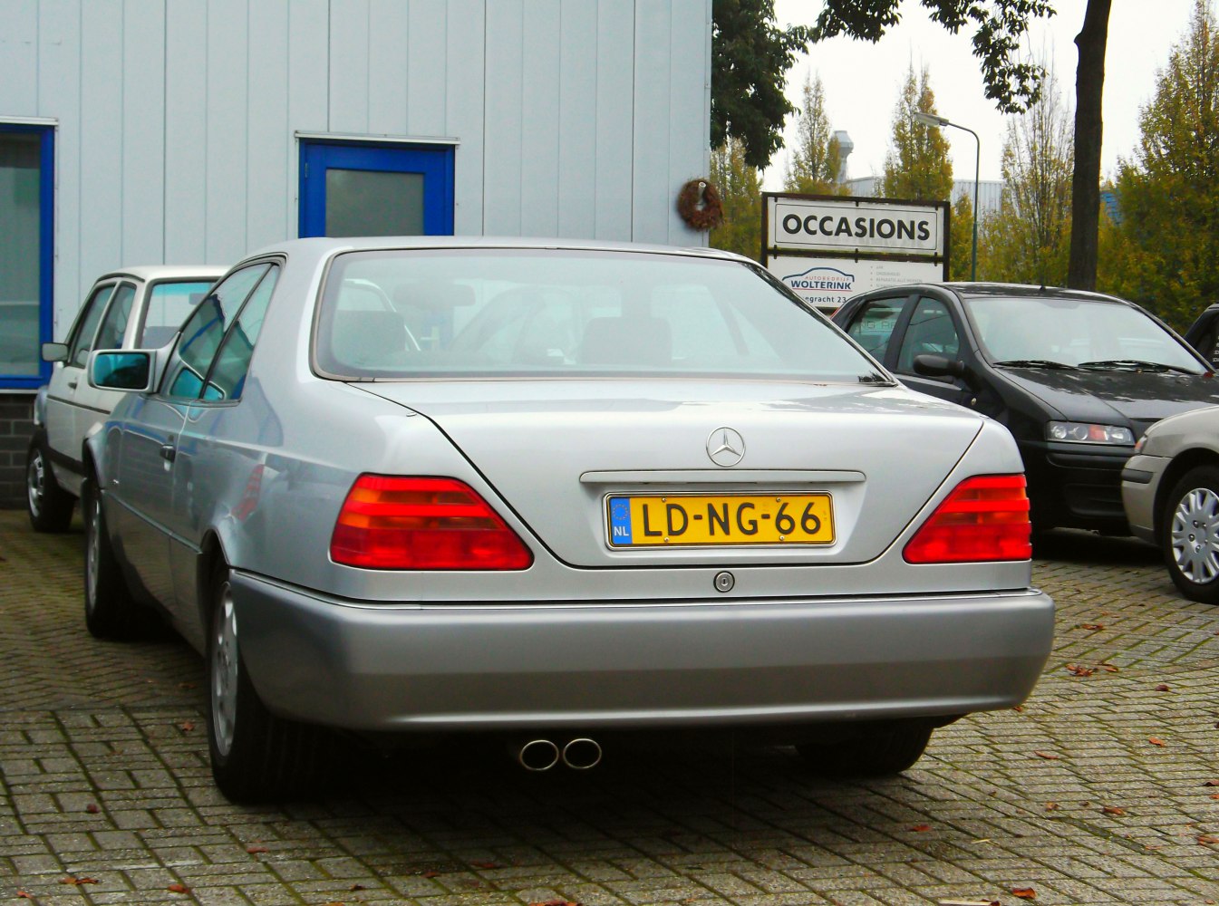 Rear view of a silver coupe with dual exhaust and distinctive taillights