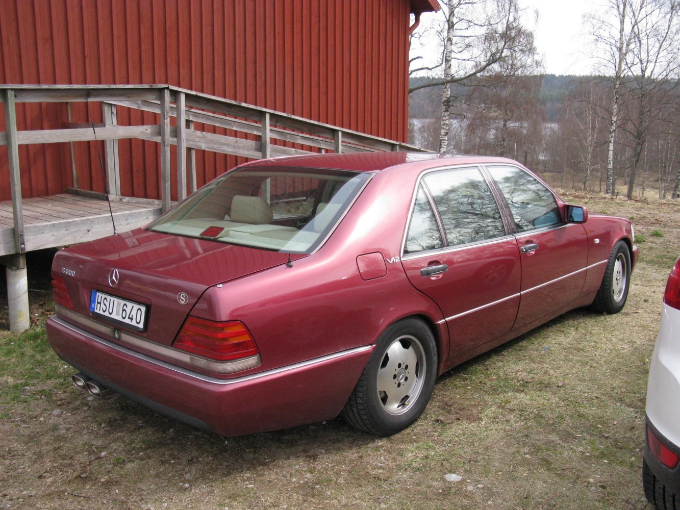 Rear and side view of a luxury sedan with V12 badge
