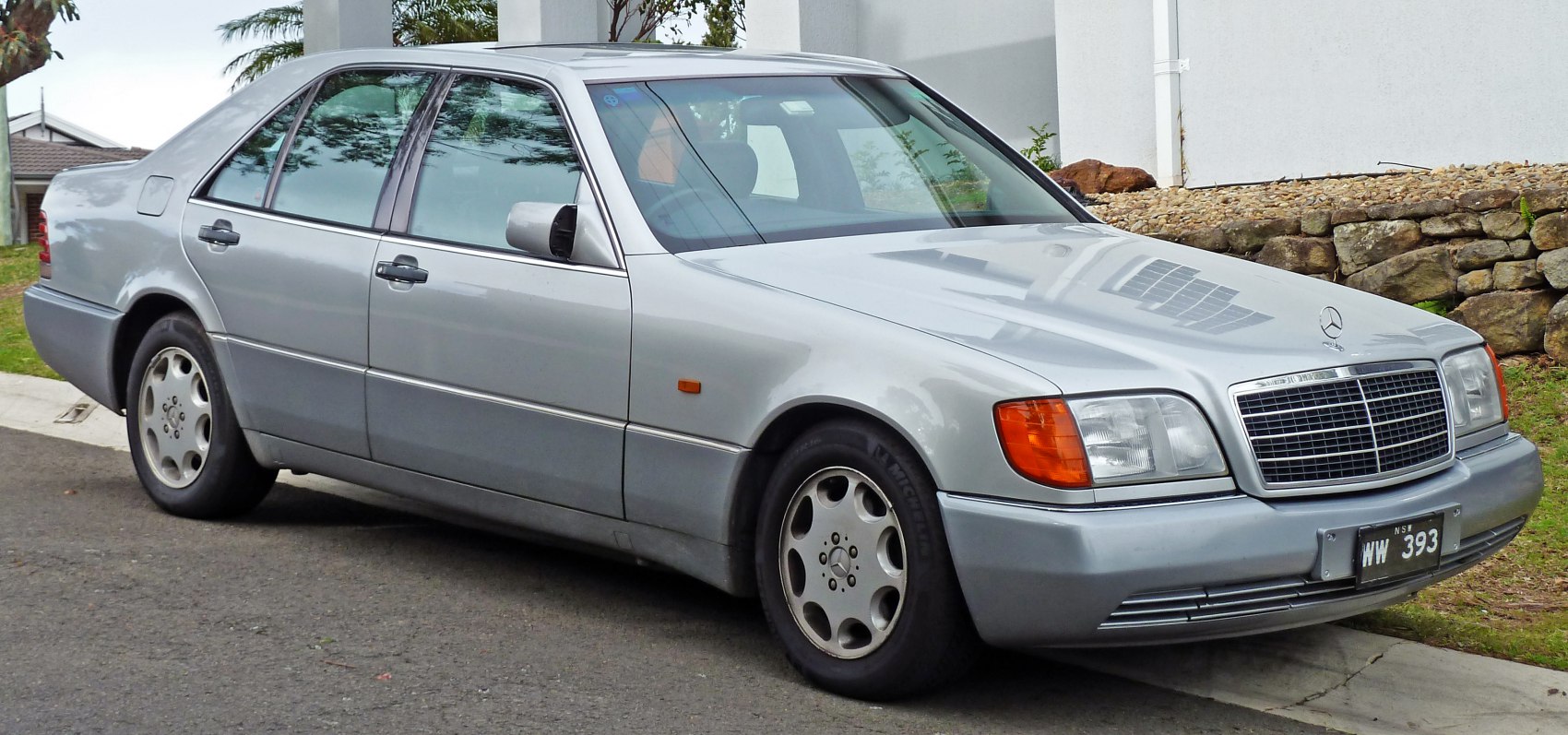 Chrome grille, round dual headlights, alloy wheels on classic sedan profile