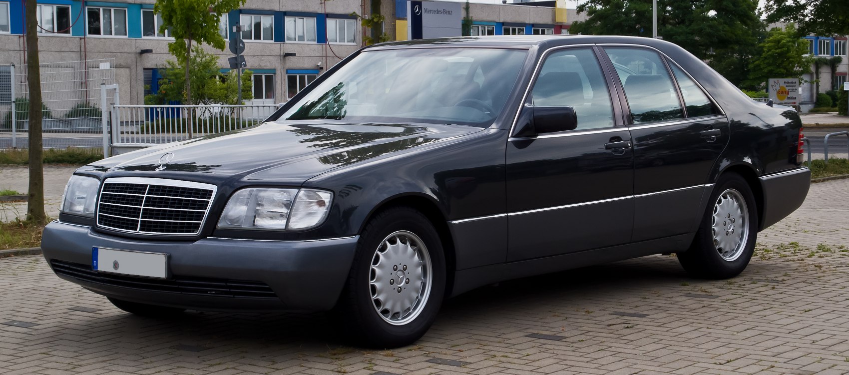 Luxury sedan with alloy wheels and bold front grille from front side view