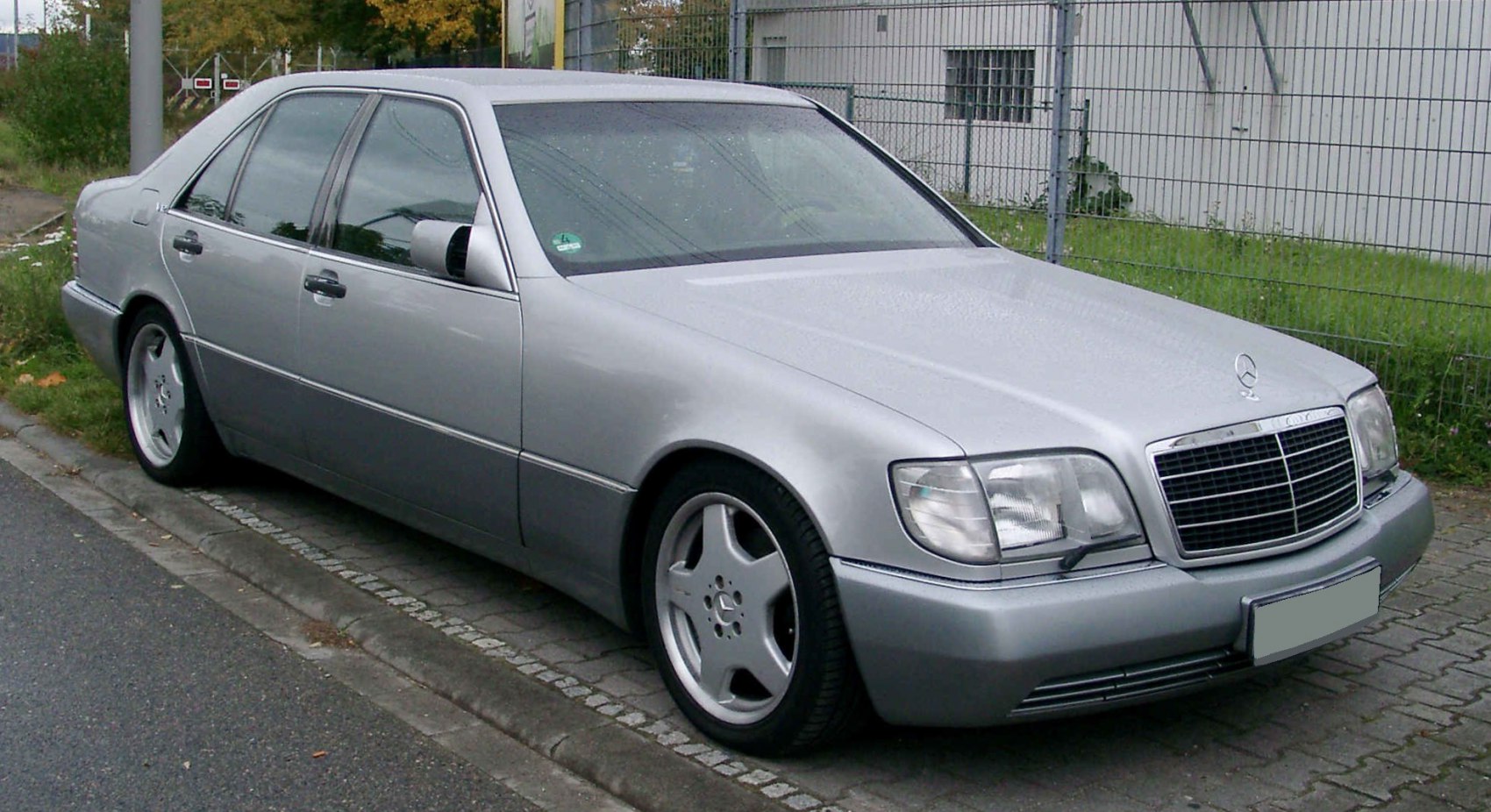Front and side profile of silver luxury four-door sedan with distinctive grille and unique alloy wheels.