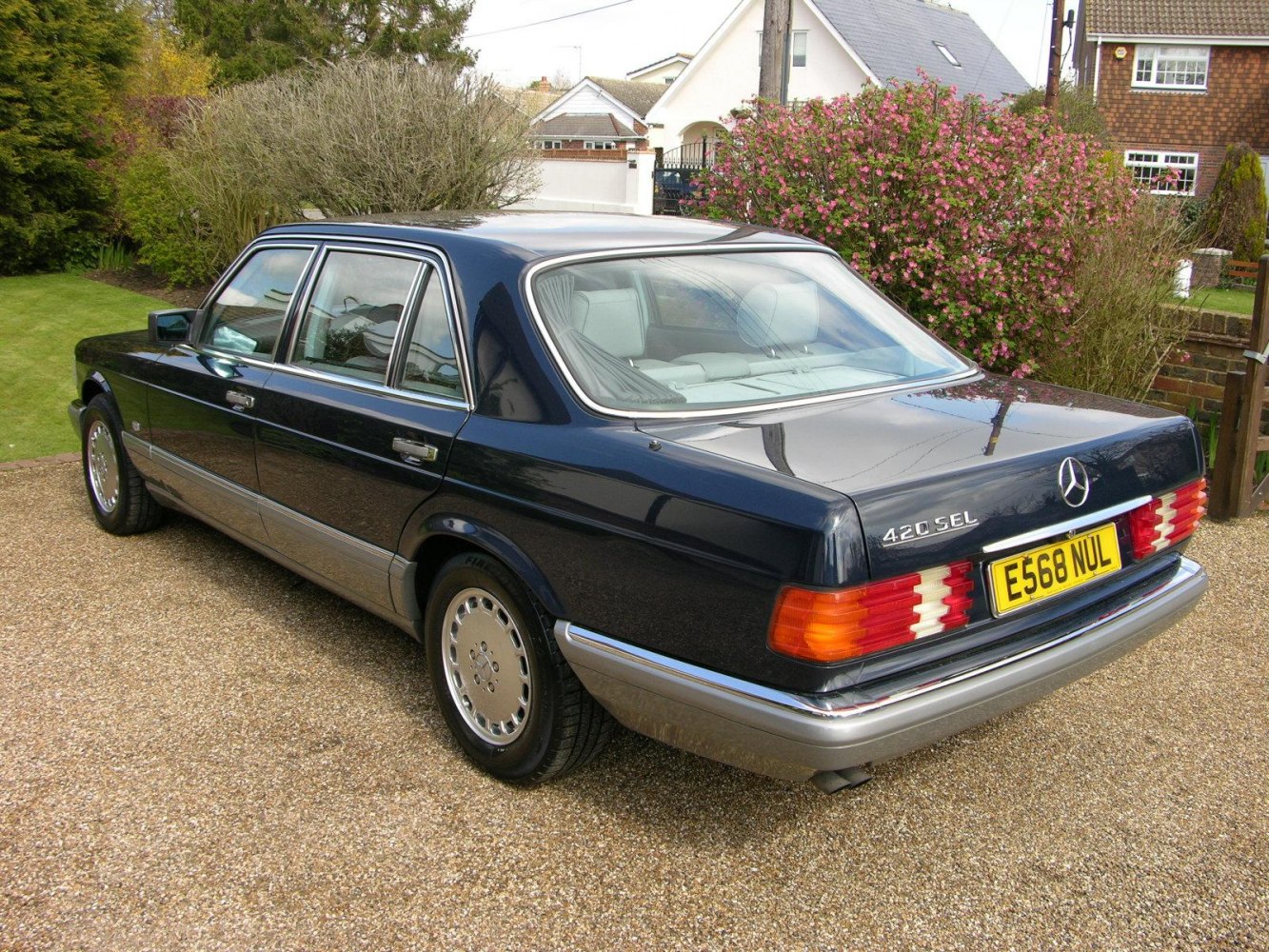 Rear and side view of a classic luxury sedan with polished wheels and distinct tail lights