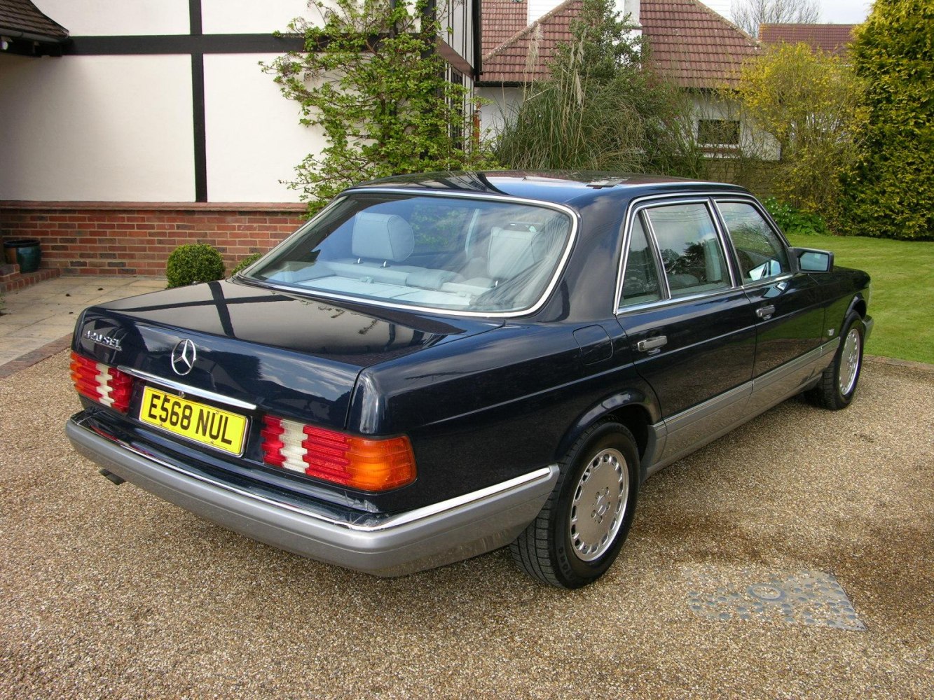 Rear 3/4 view of classic luxury sedan with distinctive tail lights and chrome trim